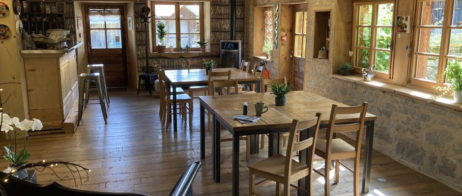 La salle commune de l'Arbre à Chapeaux avec des tables individuelles ou à partager et son espace bar