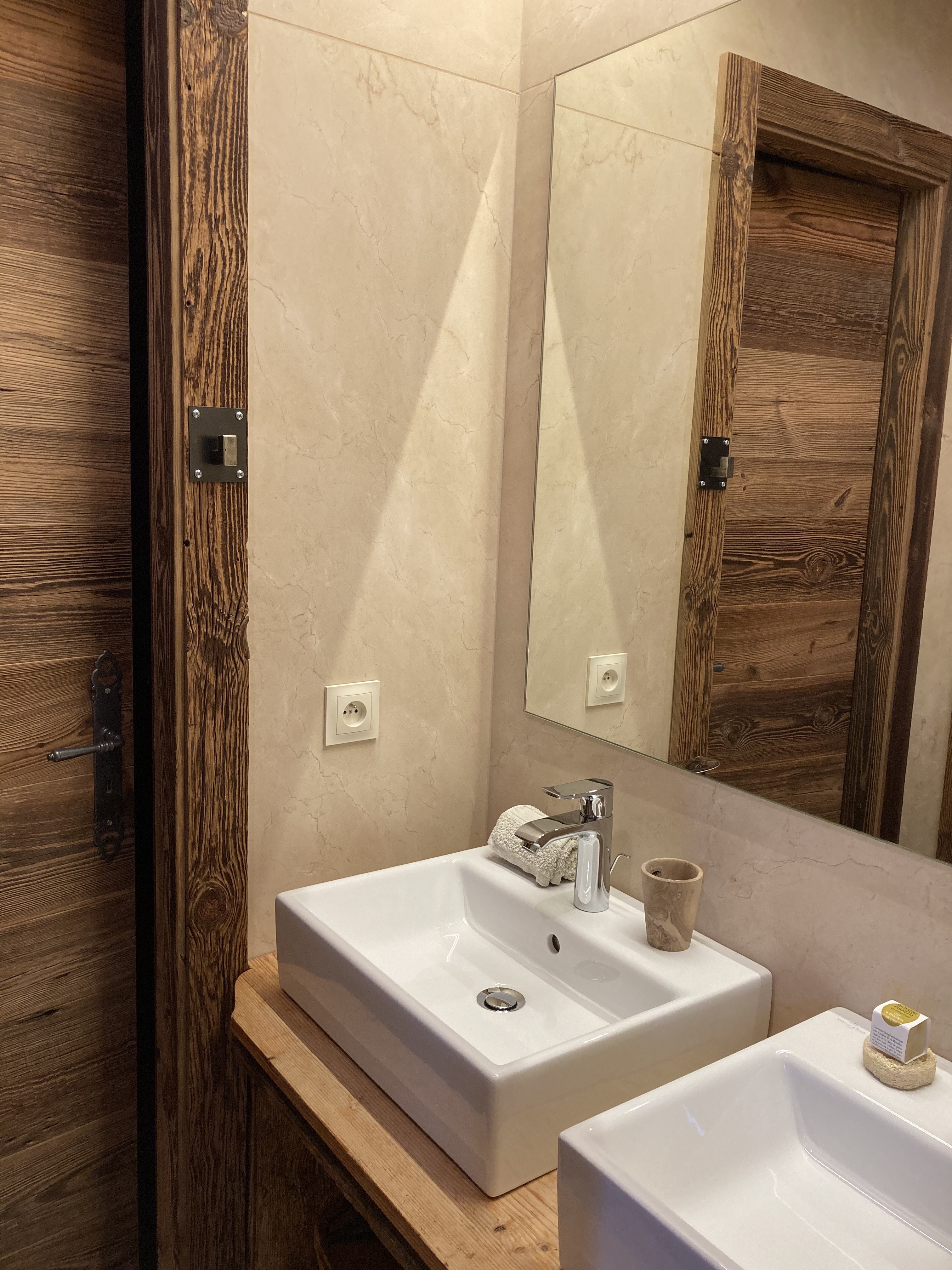 La salle de bain équipée de deux vasques, de toilettes indépendantes et d'une douche à l'italienne.